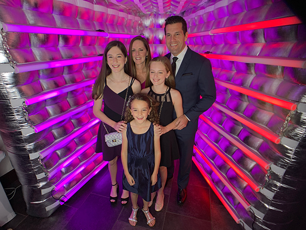 Family portrait inside a glowing inflatable photo booth
